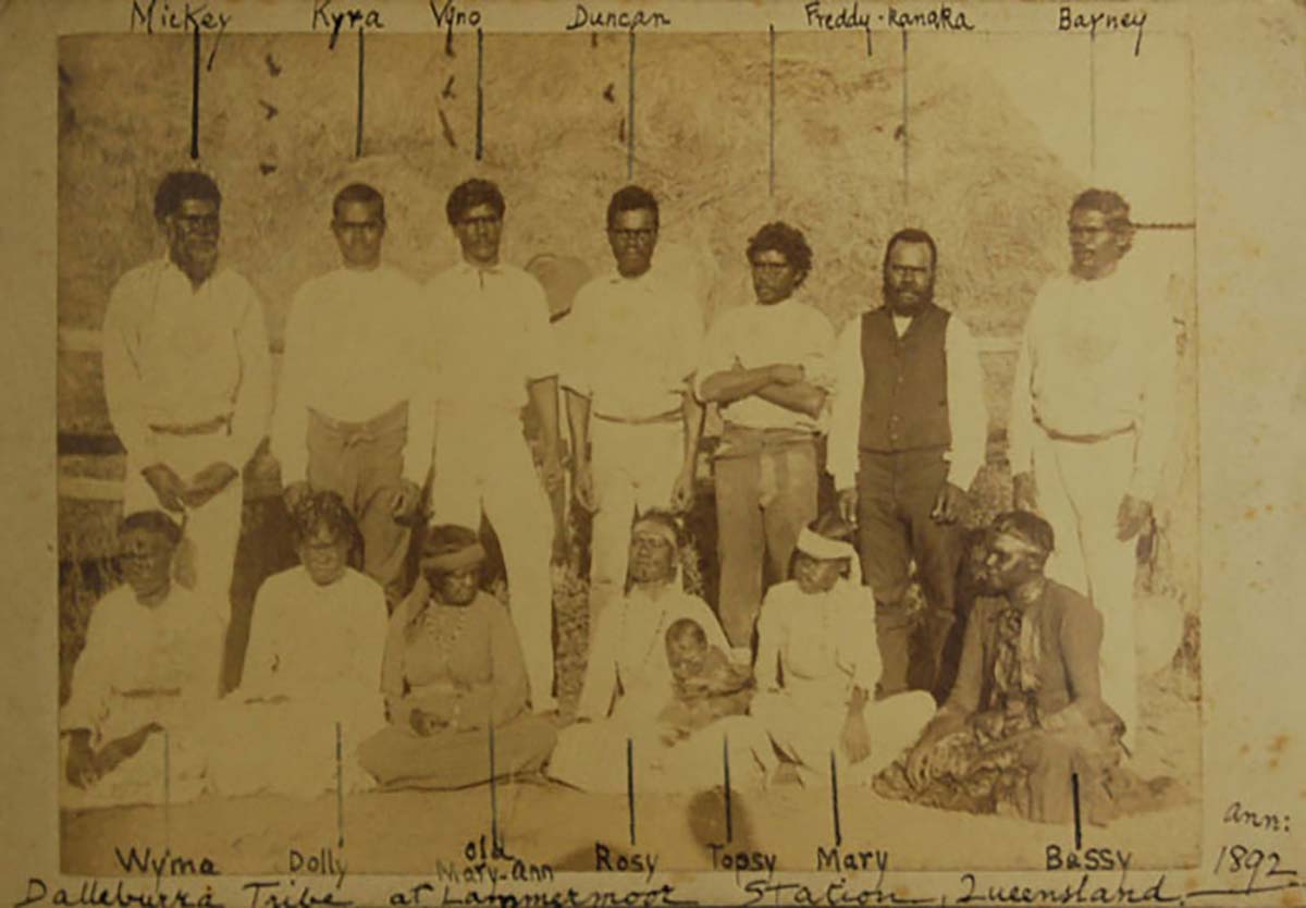 An old sepia photo of a group of men, women and children.