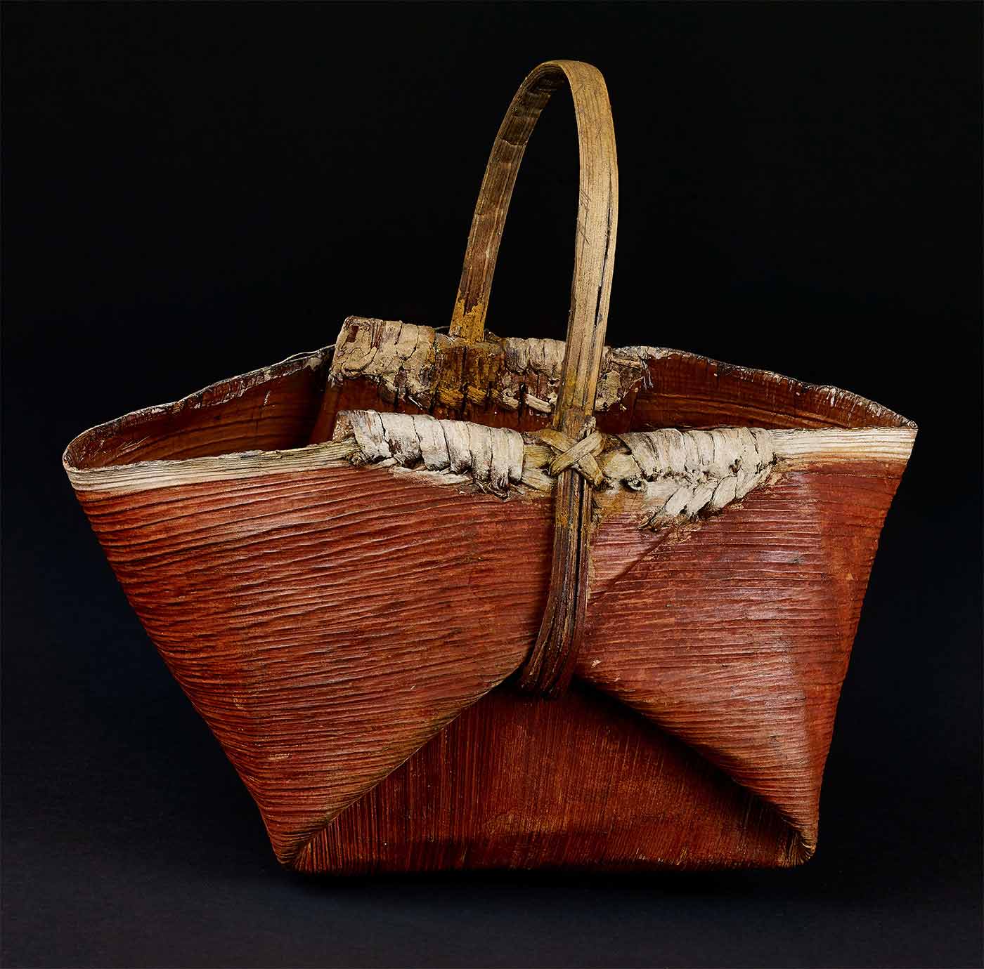 Basket made of vegetable fibre. Closely twined with complex painted decoration in white, red and dark green ochre, covering two thirds of basket leaving one section plain.