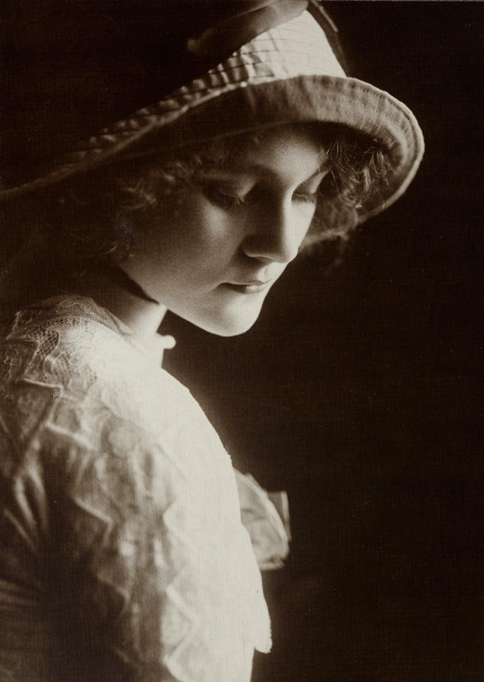 Photograph of a woman gazing down to her right.