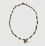 Necklace tuinga kahoa Oz 191 Necklace consisting of flat white shells, brown wooden discs, small red snail shells, one larger snail shell, and one tooth arranged on string.