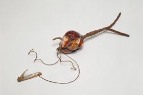 Fishing device Fishing bait or lure made of the backs of cowry shells to resemble an animal. Fishing line of plant fibre is tied to it and a mother-of-pearl hook.