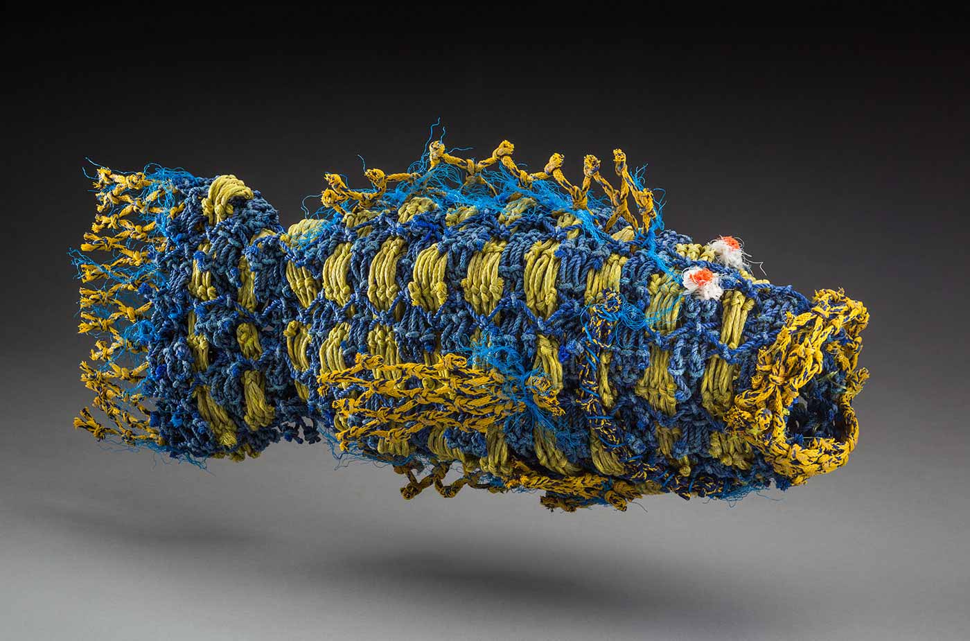 A sculpture in the shape of a fish made from a fishing net.