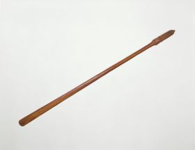 164.jpg Staff made of brown wood, the grip end decorated with line and facial ornaments.
