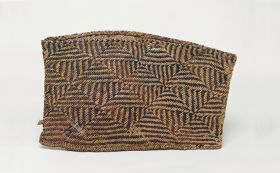 Basket kete Basket made of light and reddish to dark brown flax strips plaited in a geometric pattern.