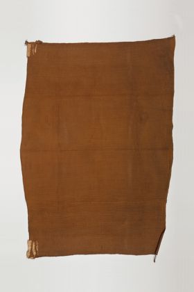 Cloak mai muka Cloak made of flax and dyed dark brown. Thick, doubled fibre cords are twisted and found on both long sides as borders.