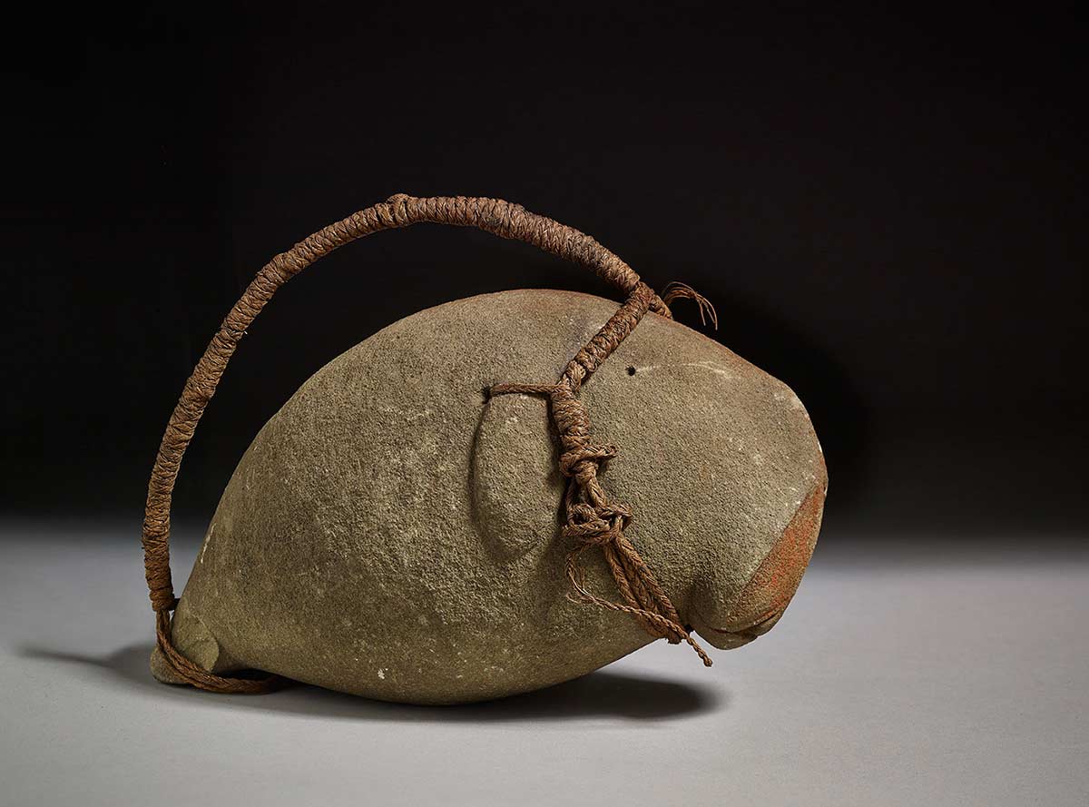 Charm resembling a dugong made from stone, ochre and fibre.