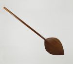 Paddle fohe Paddle made of one piece of brown wood with an oval-shaped blade that is pointed at one end.