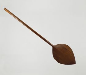 Paddle fohe Paddle made of one piece of brown wood with an oval-shaped blade that is pointed at one end.