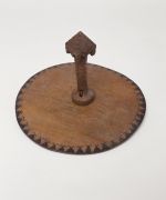 Food suspension hook taunga A food suspension made of flat, round white wood, that suspends from the ceiling. The smooth side of the rim has a pattern with one row of black triangles, each with a zigzag line on top.