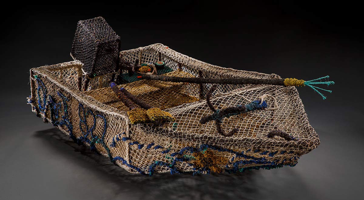 A sculpture of a dinghy made from ghost nets (nylon monofilament fishing lines).